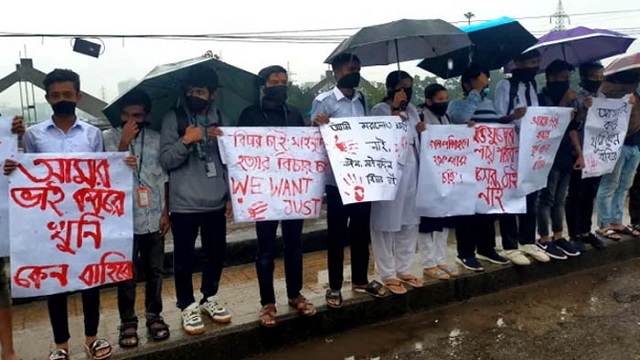 বৃষ্টি উপেক্ষা করে মুখে কালো কাপড় বেঁধে অবস্থান কর্মসূচি পালন করেছে শিক্ষার্থীরা